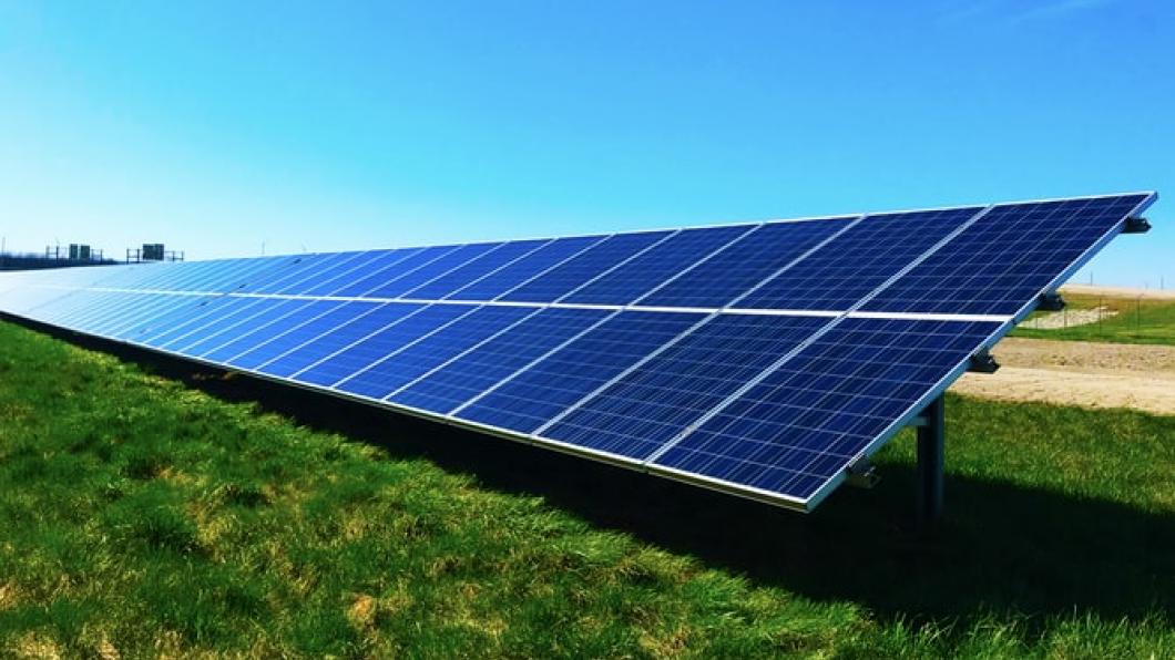 Rij zonnepanelen in een grasveld