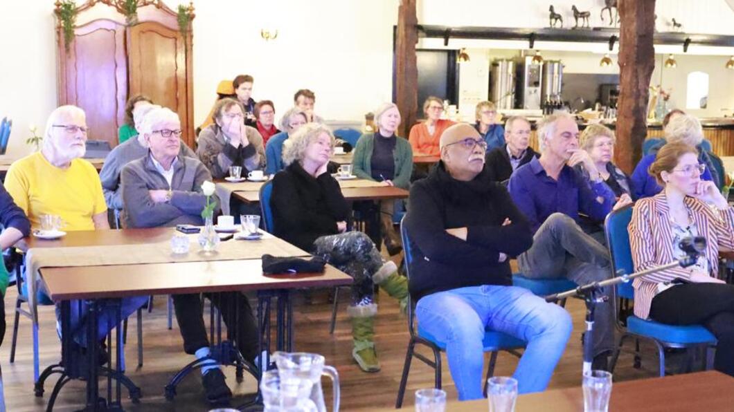 Aanwezigen kijken naar de uitleg van het plan