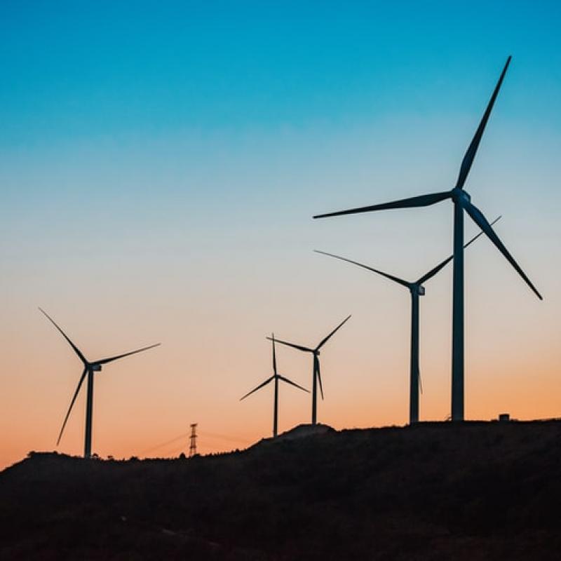 Een rij windmolens bij zonsondergang