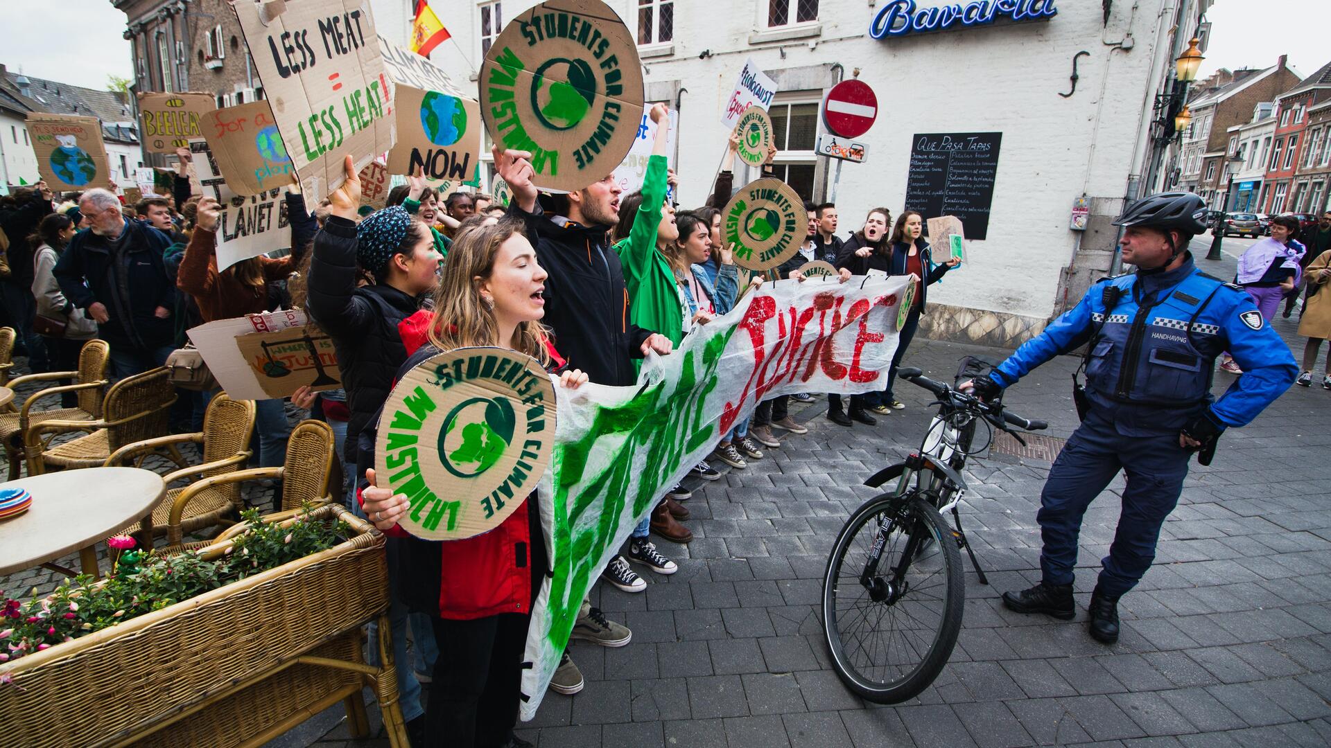 Foto van klimaatdemonstranten tegenover een BOA